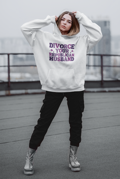 woman wearing an oversized white hoodie that says divorce your republican husband in purple font