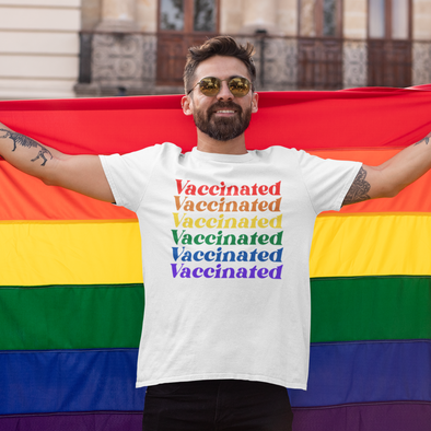 Man wearing a rainbow vaccinated shirt and holding a gay pride flag